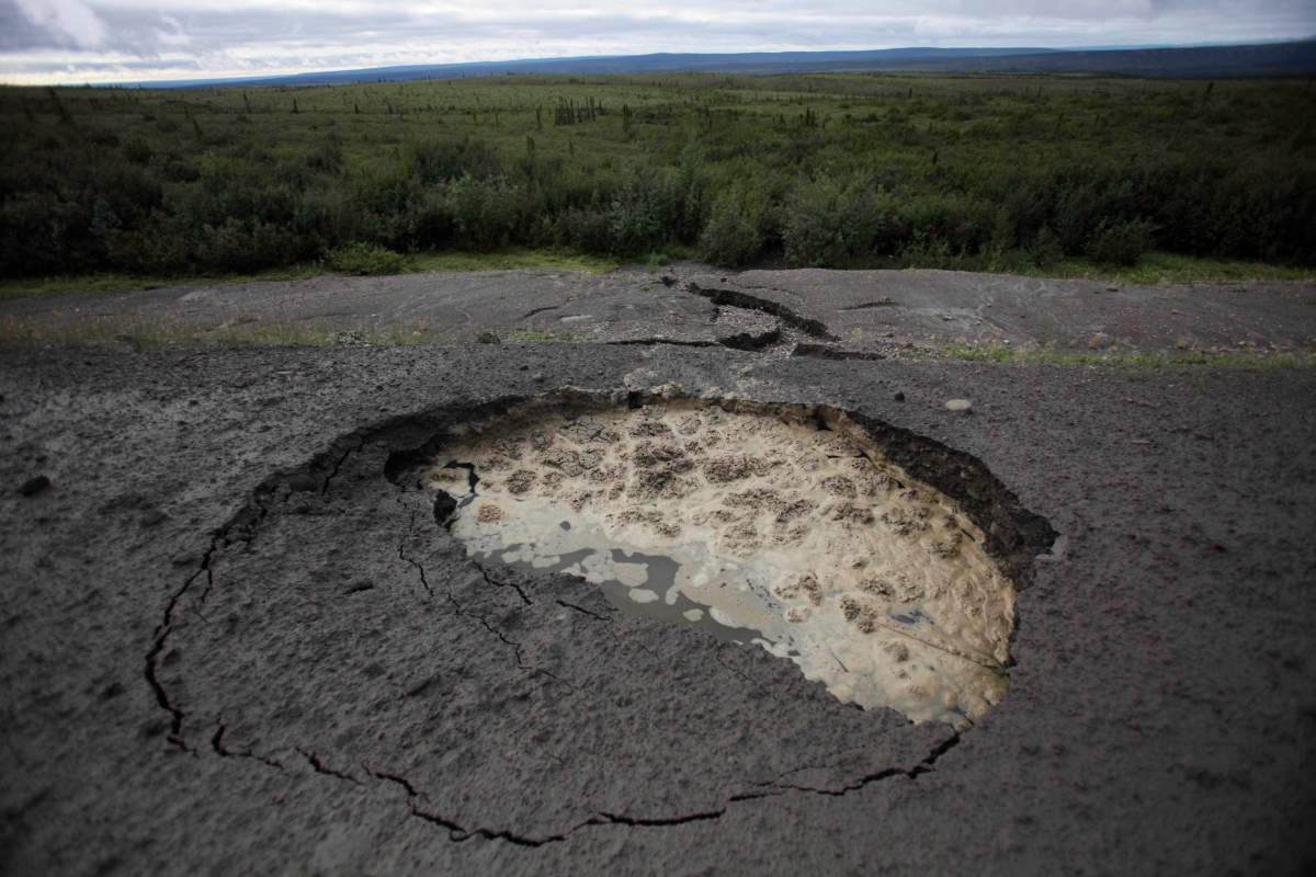 This Aug. 12, 2009, photo shows a section of the vital Dempster Highway linking southern Canada with the Northwest Territories after it collapsed because warming temperatures caused the permafrost below to thaw.