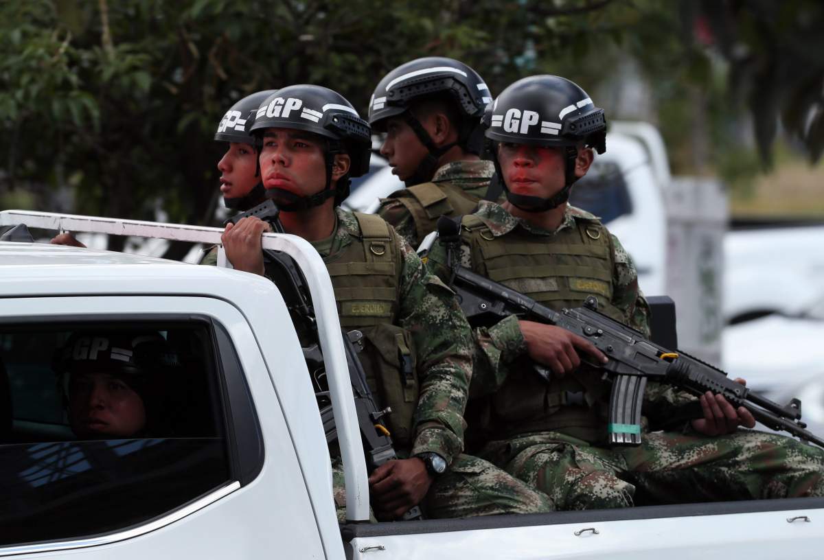 Members of the Colombian Army attend to the place where a bomb car caused an explosion at the Escuela General Santander de la Policia (Santander General Police School) in Bogota, Colombia.