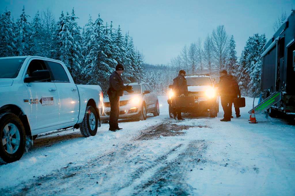 RCMP officers switch between shifts near their roadblock as supporters of the Unist'ot'en camp and Wet'suwet'en First Nation gather at a camp fire off a logging road near Houston, B.C., on Wednesday, January 9, 2019.