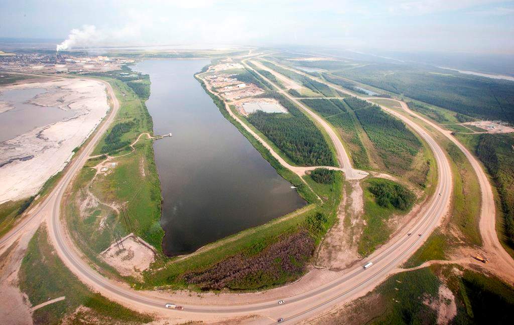 A highway loops around a tailings pond at the Syncrude facility as seen from a helicopter tour of the oil sands near Fort McMurray, Alta., on July 10, 2012.  THE CANADIAN PRESS/Jeff McIntosh.