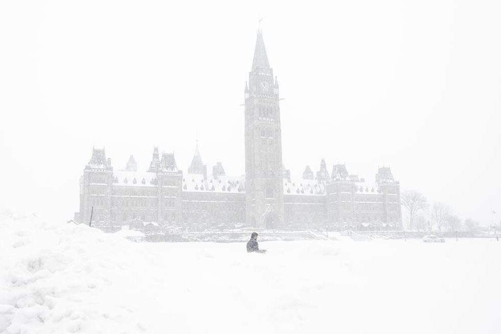 A pedestrian walks past a snowbank on Parliament Hill in Ottawa on Sunday, January 20, 2019.