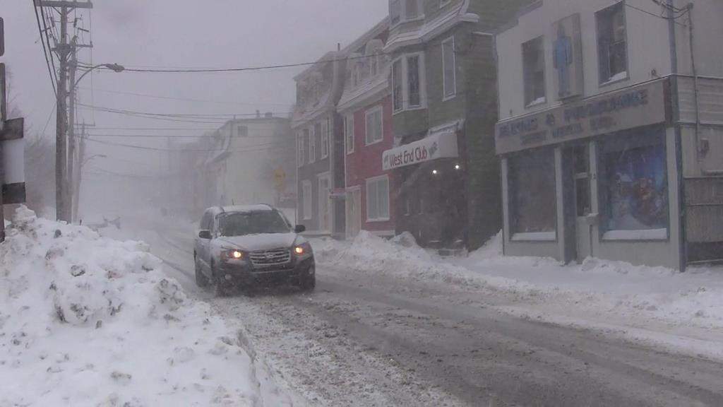A car drives downs a snow-covered street in St. John's on Wednesday, Jan. 2, 2019. Disgruntled St. John's residents took to the streets early Wednesday afternoon to shovel away snow from a powerful storm, just before a second round of intense wind and snowfall began battering Newfoundland and Labrador.