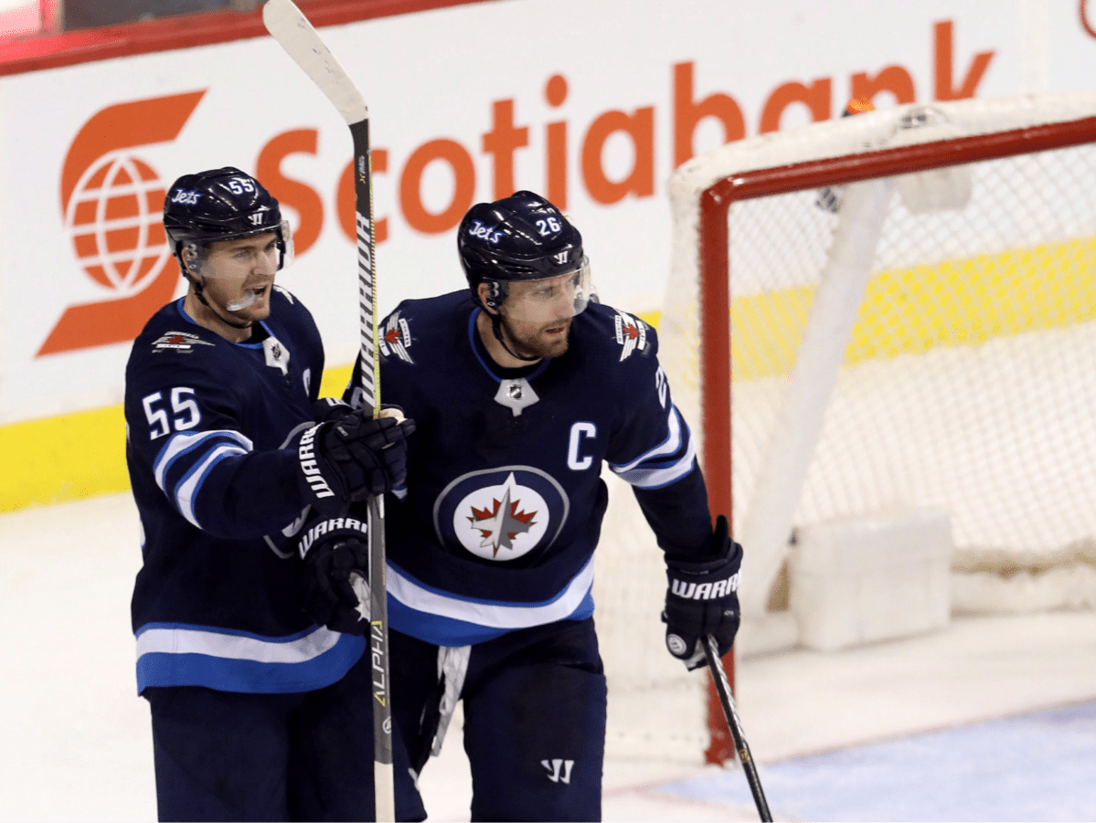 Winnipeg Jets' Mark Scheifele (55) and Blake Wheeler (26) celebrate after Scheifele scored against the St. Louis Blues during third period NHL hockey action in Winnipeg. 