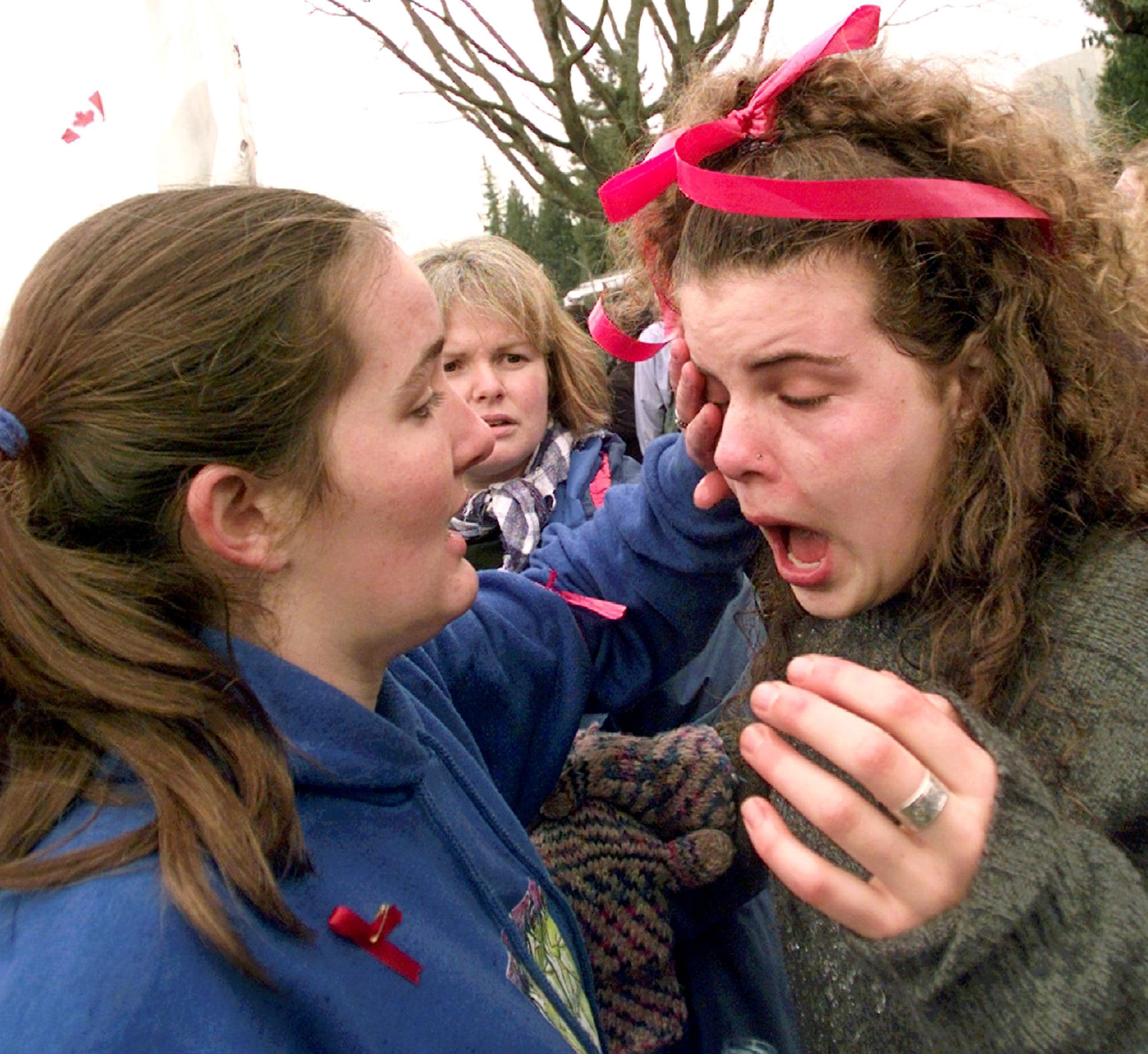 A demonstrator is assisted after getting pepper spray in her eyes when police used the spray to break up a demonstration outside the University of British Columbia, the site of the APEC Summit in Vancouver, Canada, Tuesday, Nov. 25, 1997.