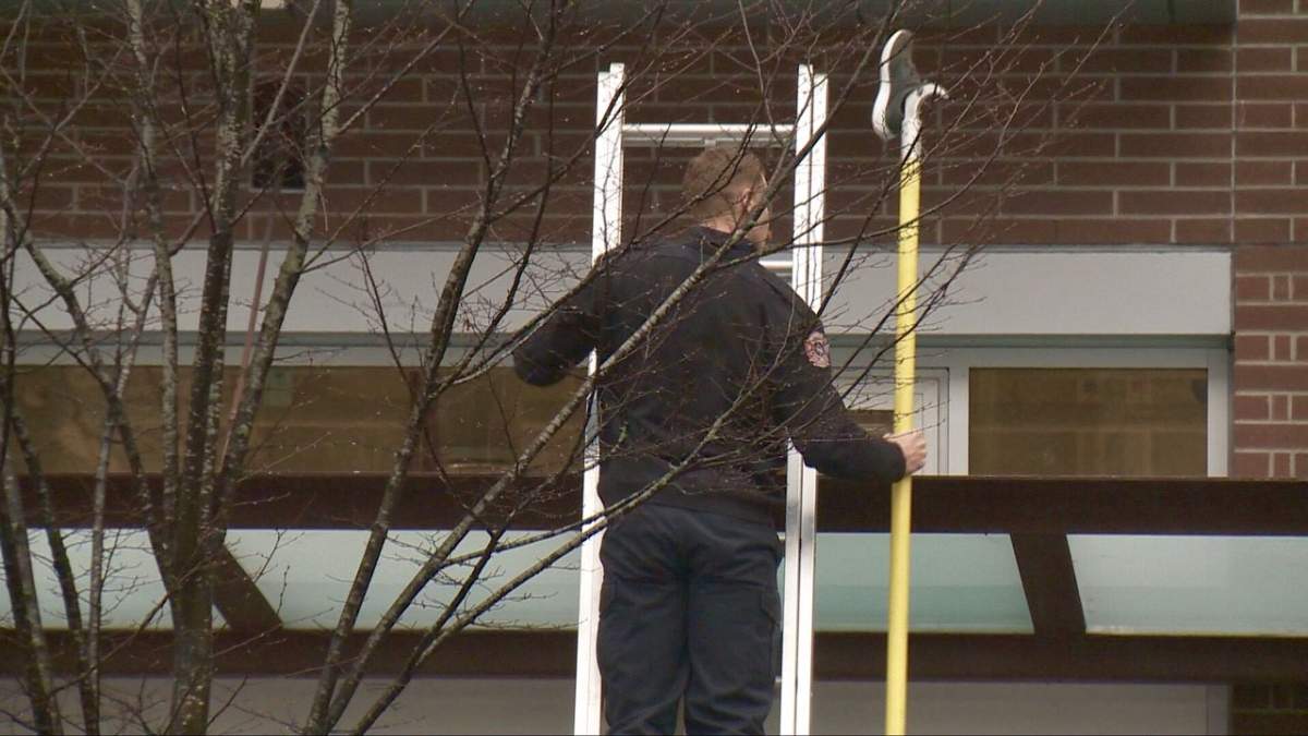 A first responder removes a shoe from atop an awning after a woman fell four storeys on Tuesday. 