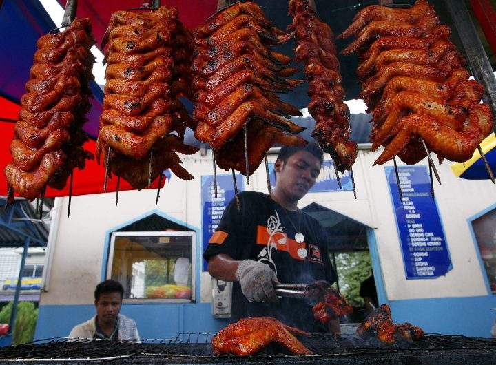 A Malaysian man prepares grilled chicken wings for sale at Ramadan bazaar in Kuala Lumpur, Malaysia, Thursday, Sept. 13, 2007.