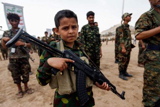 In this July 16, 2017 file photo, a Yemeni boy poses with an assault rifle during a gathering of newly-recruited Houthi fighters in the Yemeni capital Sanaa.