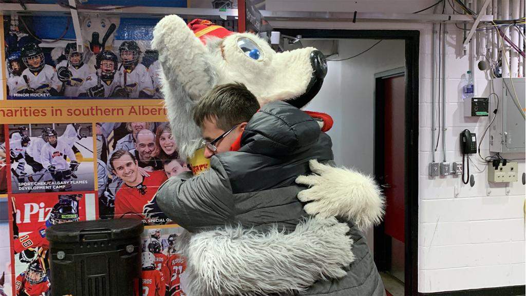 Calgary Flames goalie David Rittich’s brother hugs team mascot Harvey the Hound.