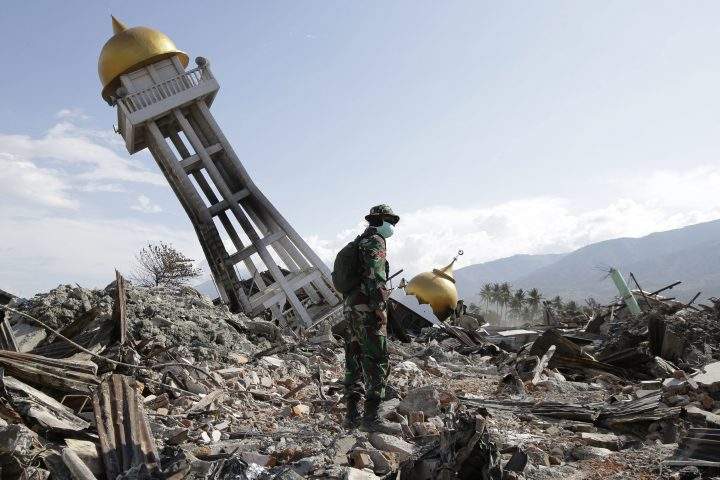 In this Oct. 6, 2018 file photo, a soldier stands near a toppled mosque as recovery efforts continue at the earthquake-hit Balaroa neighborhood in Palu, Central Sulawesi, Indonesia.
