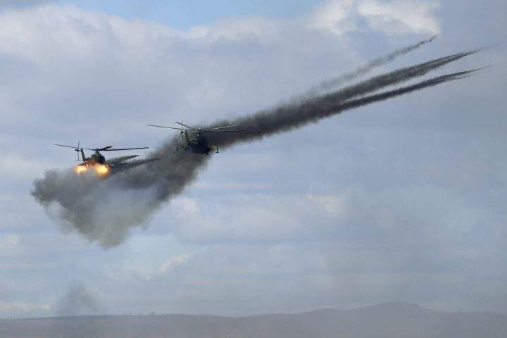 In this Thursday, Sept. 13, 2018 file photo, military helicopters fire weapons about 250 kilometres north of the city of Chita during the Vostok military exercises in Eastern Siberia, Russia.