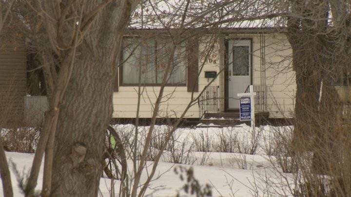 A for sale sign sits in front of a house in Estevan, Sask.