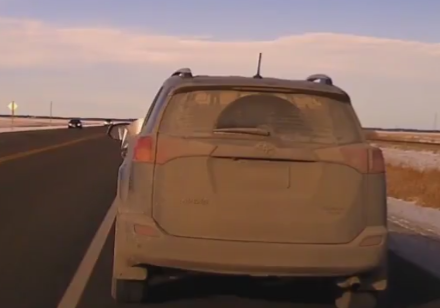 The driver holds the ticket out the window.