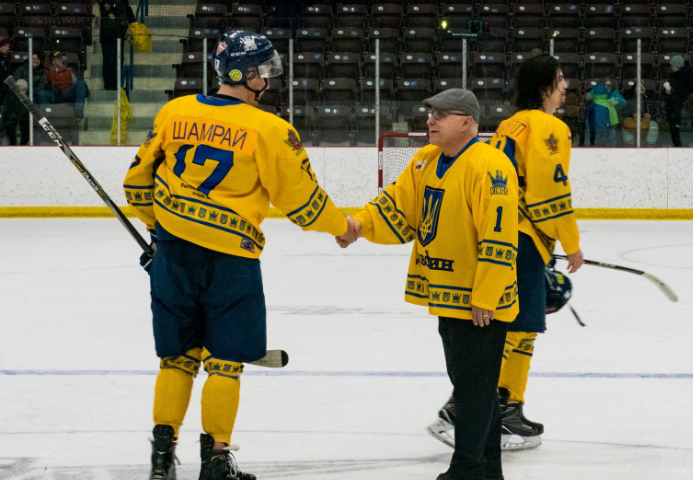 Barry Trotz shakes hands with Kings team captain Riley Shamray in their special edition Ukrainian Night jerseys.