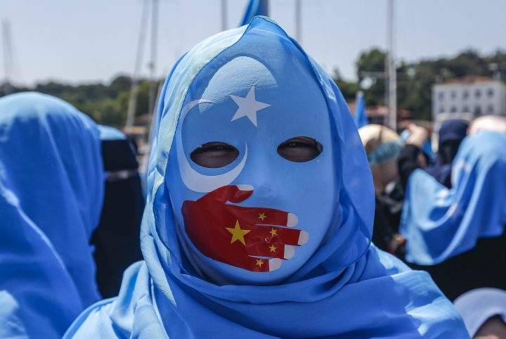 A supporter of the mostly Muslim Uighur minority wears a mask decorated in the colours of the East Turkestan flag, with a China flag-inspired hand over its mouth, at a protest in Istanbul, Turkey, on July 5, 2018.
