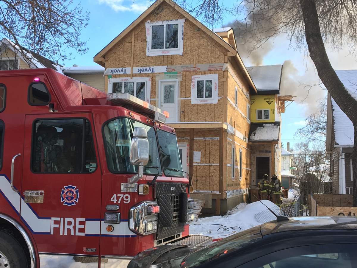 Smoke can be seen coming from a house that's under construction near 93 Street and 108 Avenue in Edmonton, Feb. 28, 2019.