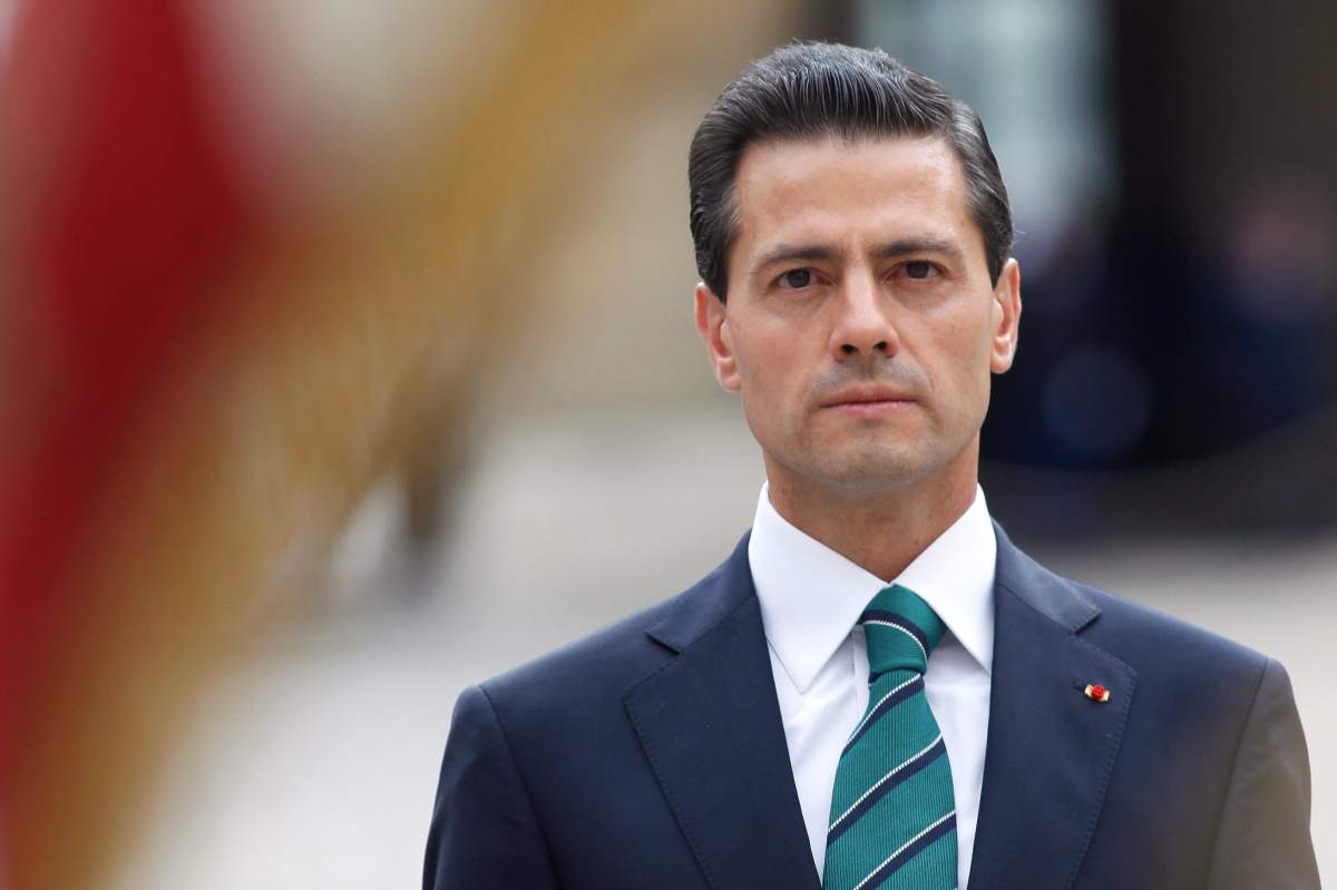 Mexican President Enrique Pena Nieto observes the French flag during a welcoming ceremony, in Paris, Monday, July 13, 2015.