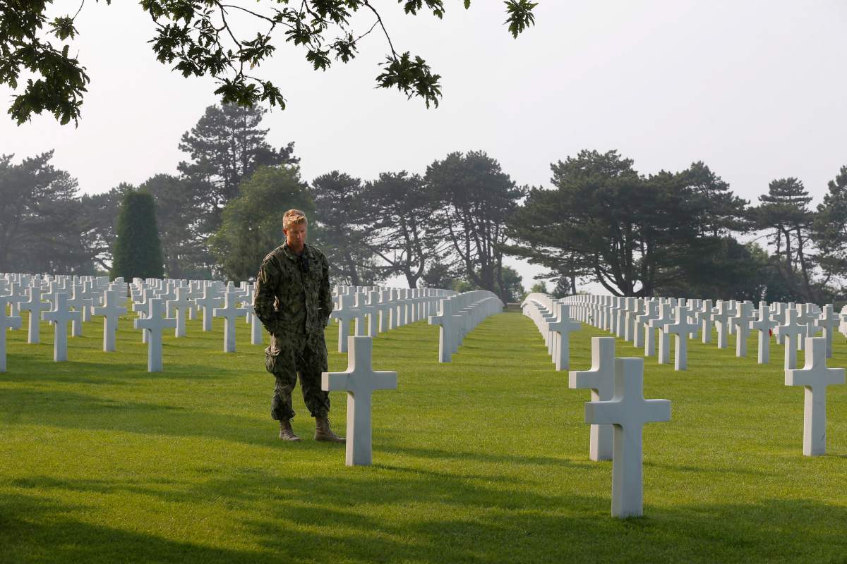 American E6 soldier, John, from Virginia Beach, whose grandfather was a pilot in the Canadian Air Force during WWII, pays respect in the Colleville American military cemetery, in Colleville sur Mer, western France, Sunday June 5, 2016, on the eve of the 72nd anniversary of the D-Day landing.
