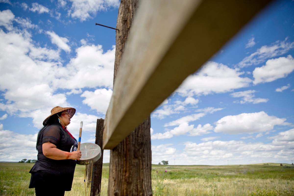 In this July 11, 2018 file photo, Roxanne White, whose aunt was murdered in 1996, sings and drums a women’s warrior and honor song created for missing and murdered indigenous women, before joining a search in Valier, Mont., for Ashley HeavyRunner Loring, who disappeared last year from the Blackfeet Indian Reservation.