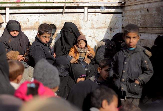 Women and children sit at a back of a bus near Baghouz, Deir Al Zor province, Syria, Feb. 11, 2019.