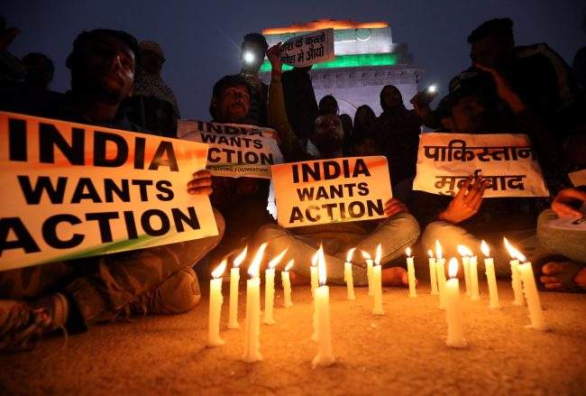 People attend a candle light vigil to pay tribute to Central Reserve Police Force personnel who were killed after a suicide bomber rammed a car into the bus carrying them in south Kashmir on Thursday, in front of India Gate war memorial in New Delhi, India, Feb. 15, 2019.