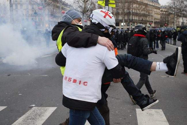 A medic carries away a demonstrator during a yellow vest protest, Saturday, Feb. 2, 2019 in Paris. France’s yellow vest protesters were back on the streets Saturday to keep pressure on French President Emmanuel Macron’s government and denounce the large number of people injured in demonstrations they say is the result of police violence. ()