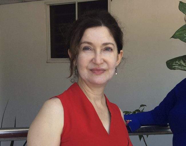 In this Oct. 2018 photo provided by Cheryl Inzunza Blum, of Tucson, Ariz., the immigration lawyer on contract with the federal government poses for a photo in Vung Tau, Vietnam.