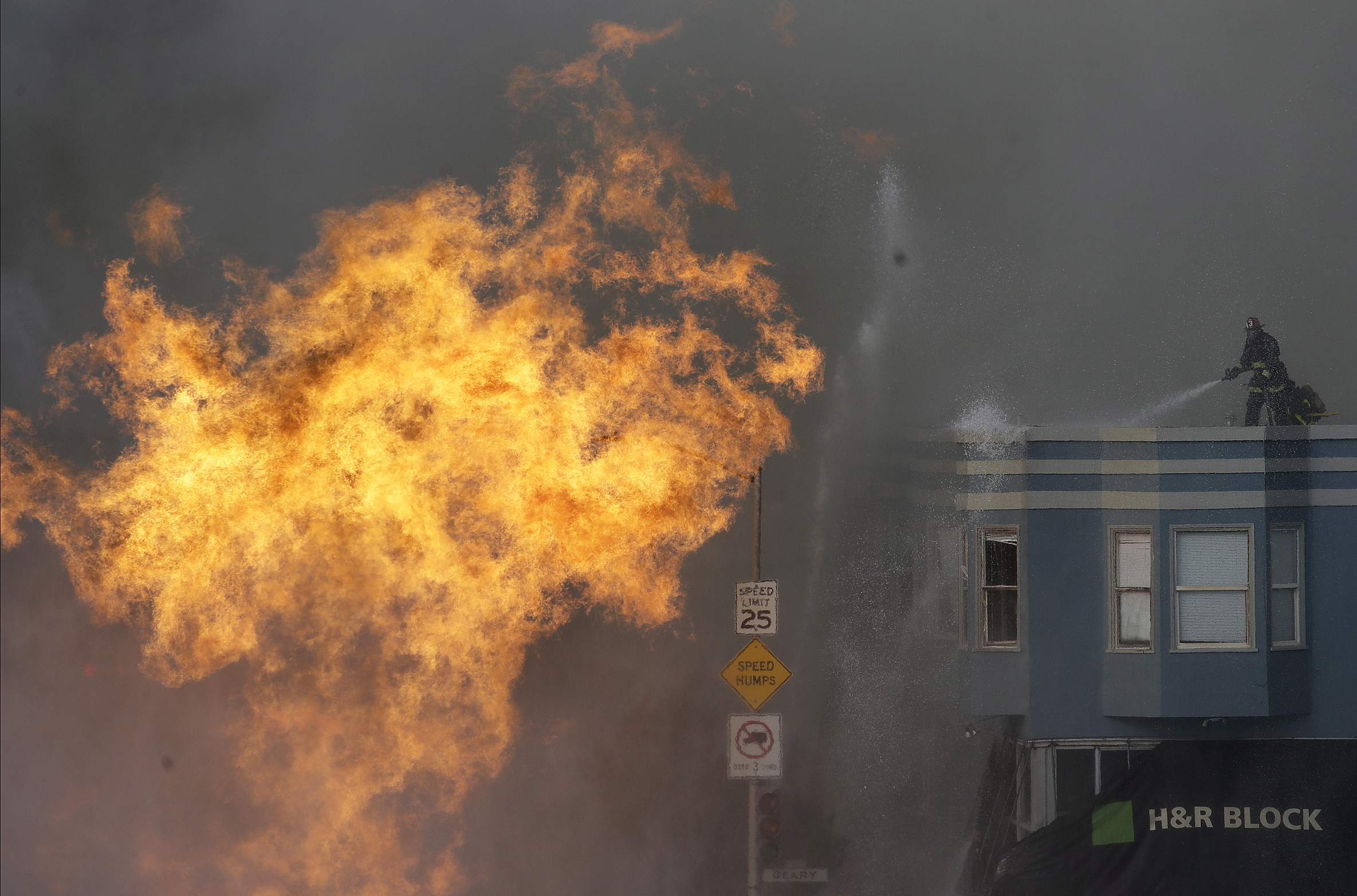 San Francisco firefighters battle a fire on Geary Boulevard in San Francisco, Wednesday, Feb. 6, 2019.