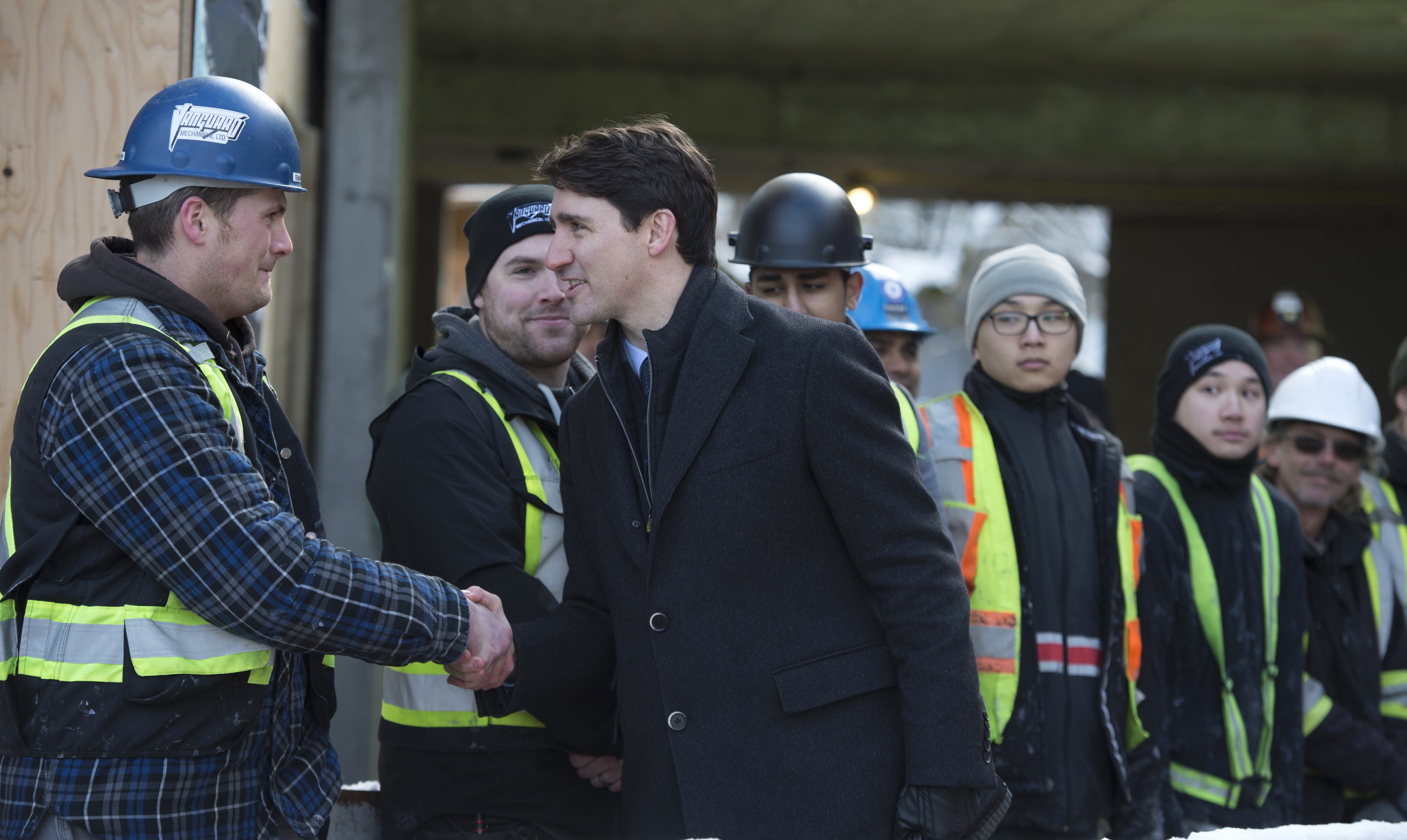 Prime Minister Justin Trudeau greets workers as he tours the Conrad rental housing development in Vancouver, Monday, Feb. 11, 2019. 