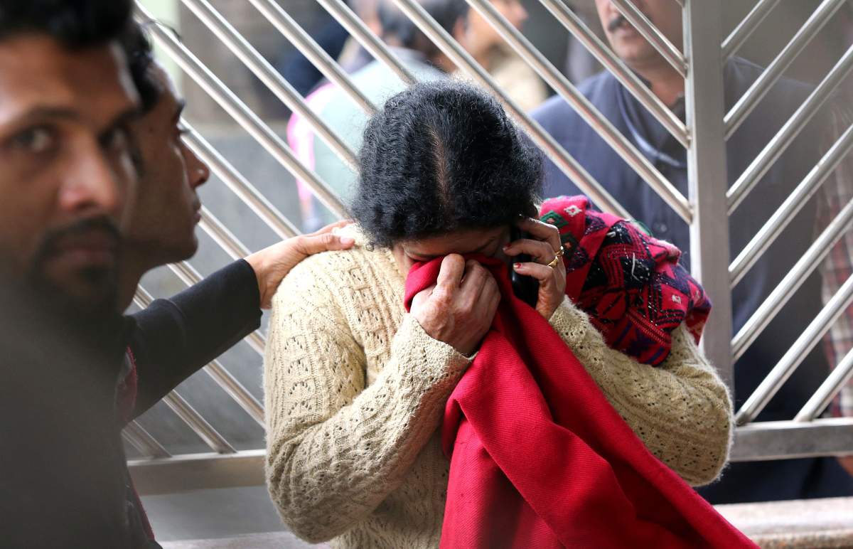 An unidentified relative of a victim mourns as other relative comforts her outside the mortuary as they wait to receive bodies of those who died in a hotel fire.