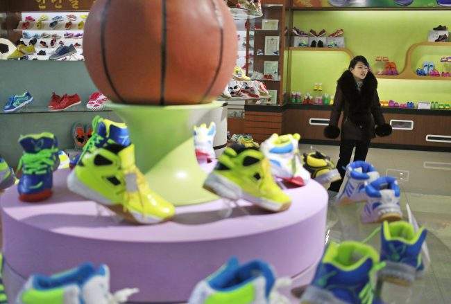 A guide stands near a basketball shoe display in a product exhibition room at the Ryuwon Shoe Factory that specializes in sports footwear, in Pyongyang, North Korea, Feb. 1, 2019. 