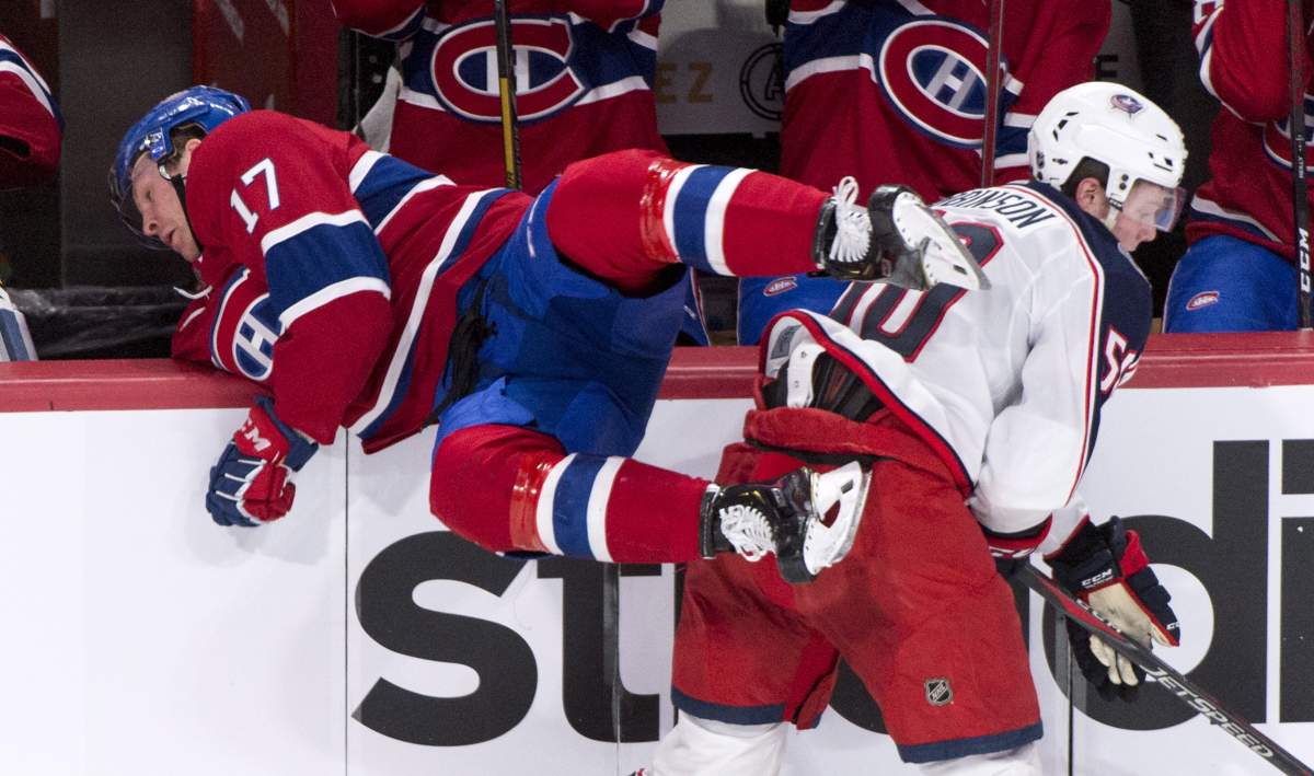 Montreal Canadiens defenceman Brett Kulak (17) is checked over the boards by Columbus Blue Jackets left wing Eric Robinson (50) during second period NHL hockey action in Montreal on Tuesday, February 19, 2019. 