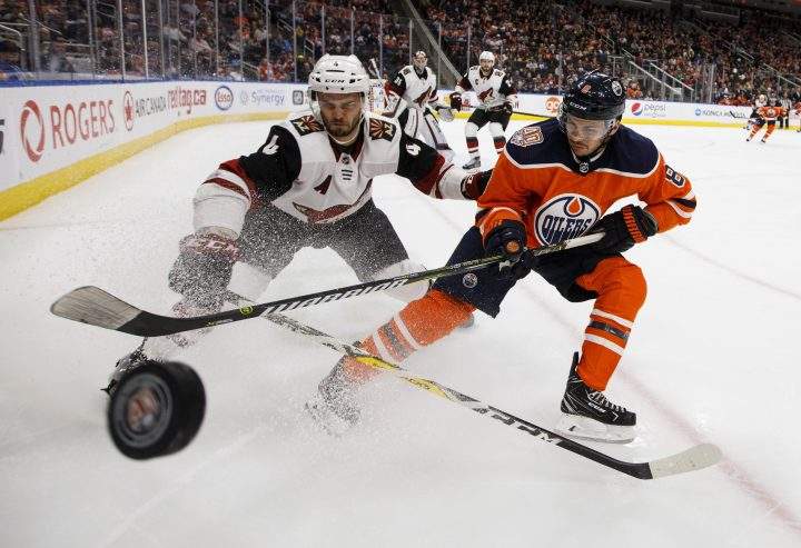 Arizona Coyotes’ Niklas Hjalmarsson (4) and Edmonton Oilers’ Ty Rattie (8) battle for the puck during second period NHL action in Edmonton, Alta., on Tuesday, Feb. 19, 2019.