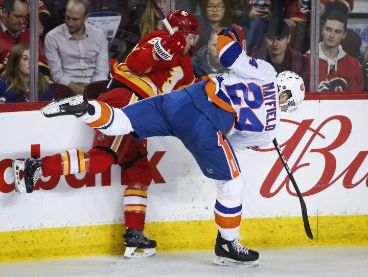 New York Islanders’ Scott Mayfield, right, checks Calgary Flames’ Sam Bennett during second period NHL hockey action in Calgary, Wednesday, Feb. 20, 2019.
