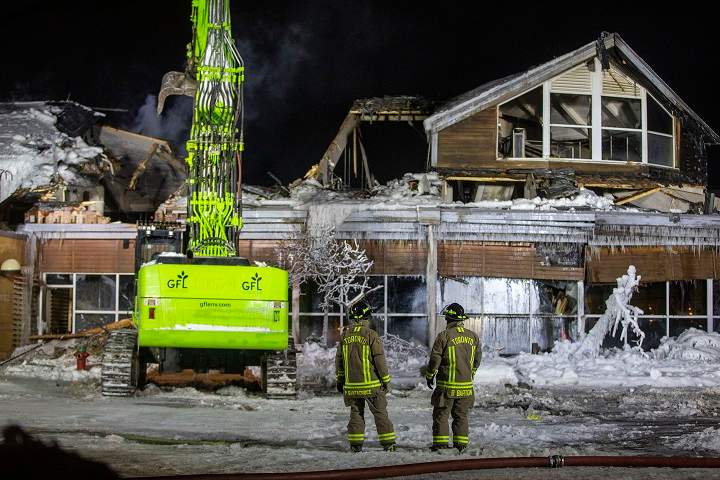 Heavy machinery was brought in Friday night to tear away parts of the roof and expose hot spots.