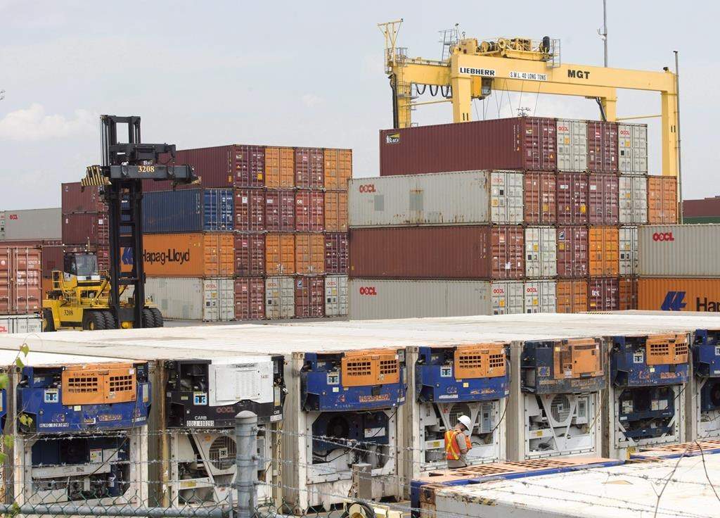 Containers are unloaded at the Port of Montreal Thursday, July 20, 2017 in Montreal. Montreal port employers and longshoremen are gearing up for a battle over the definition of "essential service" amidst ongoing negotiations for a new collective agreement.THE CANADIAN PRESS/Ryan Remiorz.