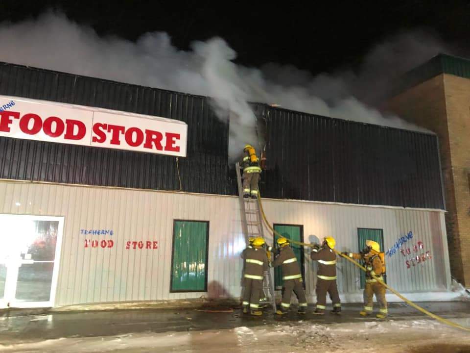 Crews work to fight the flames of the town’s local grocery store.