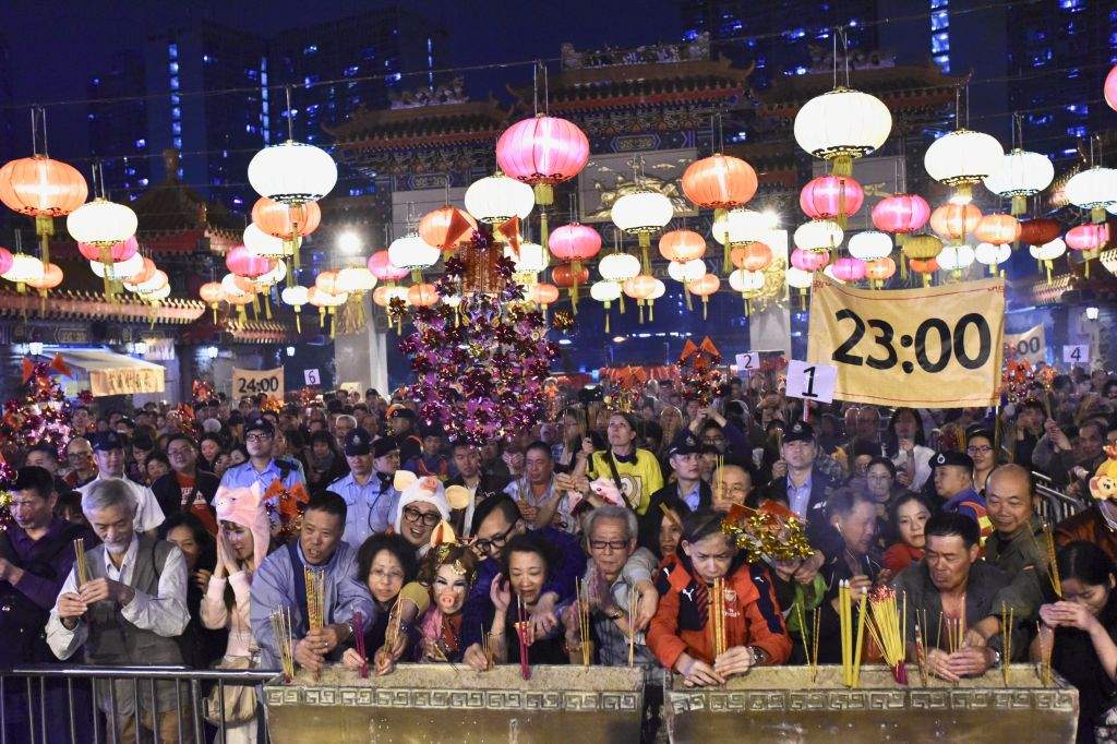 HONG KONG, CHINA – FEBRUARY 04: People burn incense sticks as they pray for good luck at the Wong Tai Sin Temple on February 4, 2019 in Hong Kong, China. The Lunar New Year, the Year of the Pig, falls on February 5 this year. 