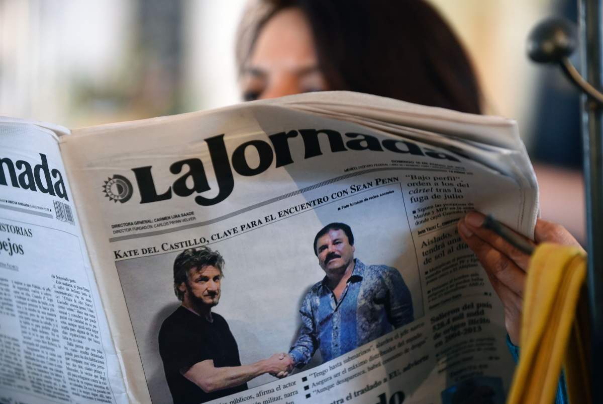 A woman reads La Jornada newspaper in Mexico City, on Jan. 10, 2016, which shows a picture of drug lord Joaquin Guzman, aka ‘El Chapo’ (R), shaking hands with U.S. actor Sean Penn.