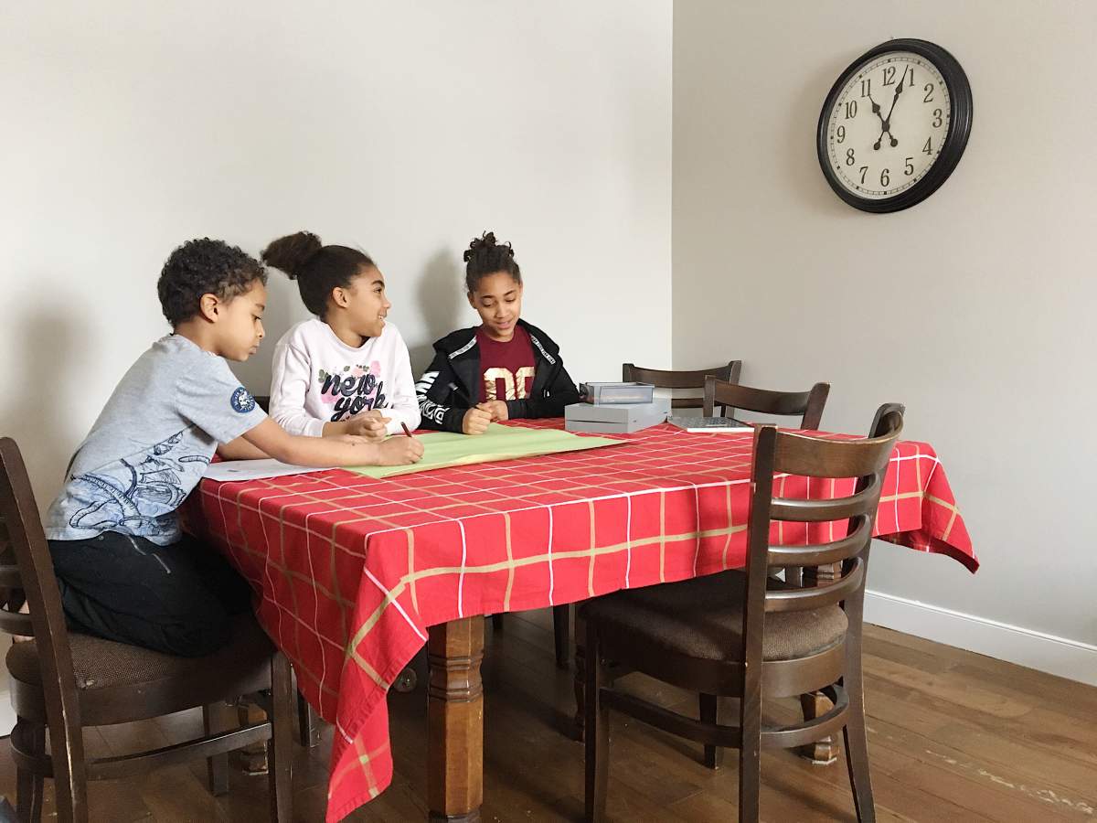 Honorat children making ‘Welcome home’ sign for their mom.
