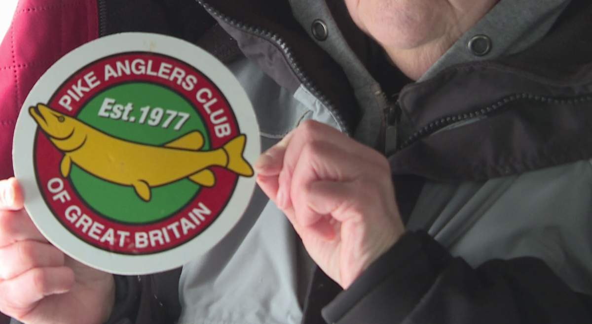 Diana Crook holds up a magnet she put on the couple’s tent that reads “Pike Anglers Club of Great Britain.”