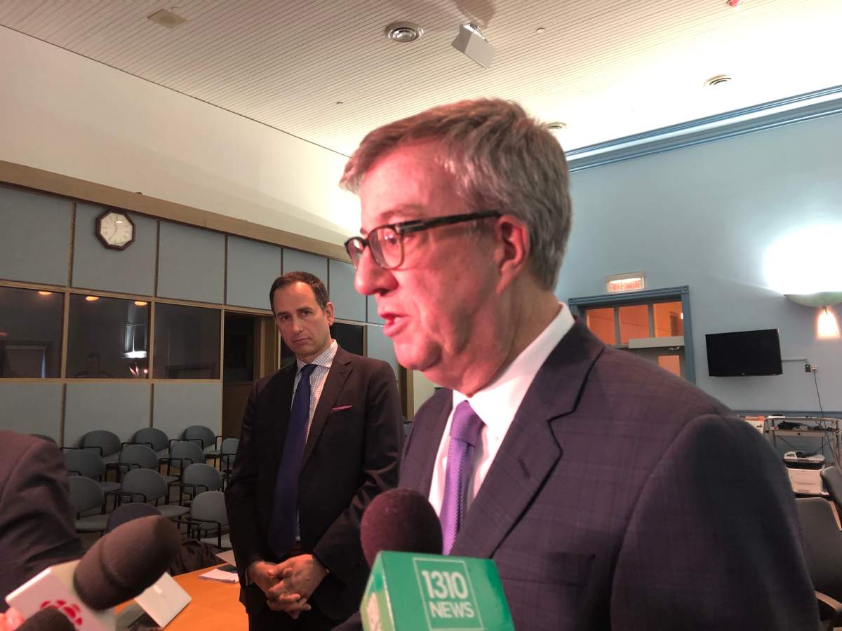 Ottawa Mayor Jim Watson speaks to reporters on Feb. 12, 2019, after receiving a status update on Ottawa’s yet-to-be-completed LRT system, while OC Transpo general manager John Manconi looks on.