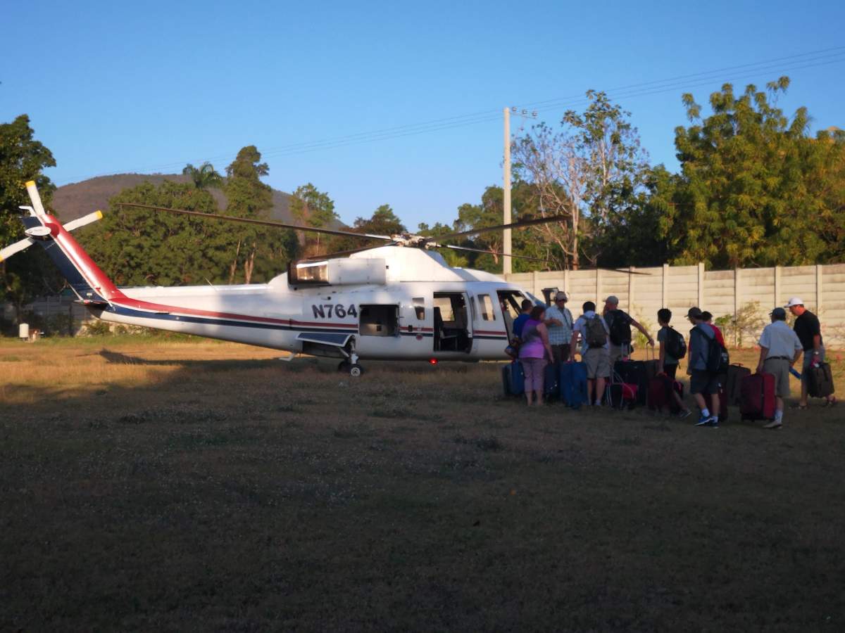 Members of Haiti Arise board a helicopter to escape escalating anti-government protests. (Courtesy Tracey Hotta)