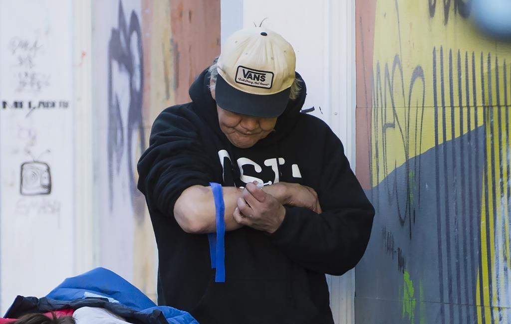 A man injects drugs in Vancouver's Downtown Eastside, Wednesday, Feb. 6, 2019.