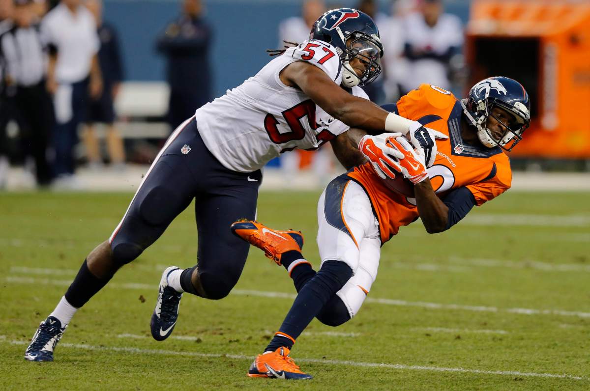 Denver Broncos wide receiver Emmanuel Sanders (10) is tackled by Houston Texans outside linebacker Justin Tuggle (57) during the first half of an NFL preseason football game, Saturday, Aug. 23, 2014, in Denver.