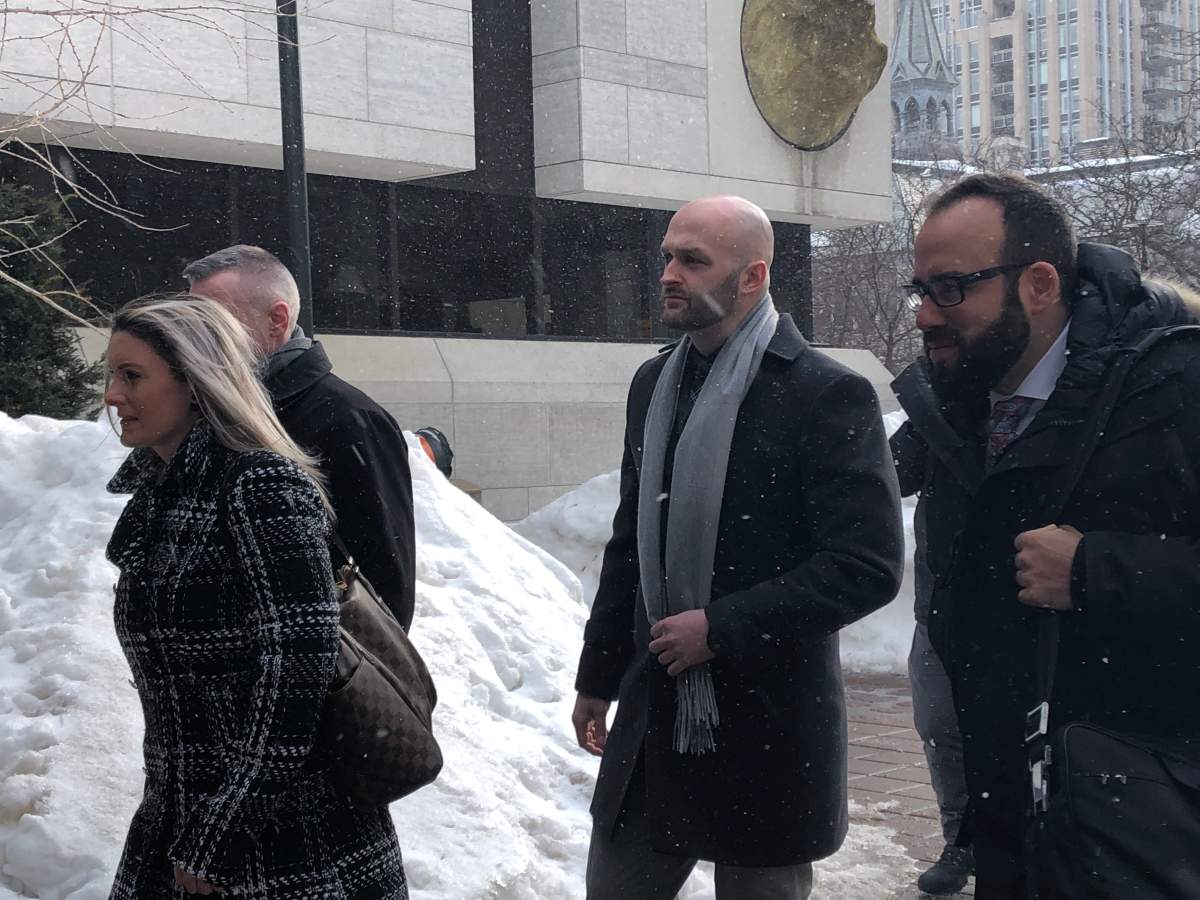 Const. Daniel Montsion (centre) arrives with his defence lawyer, Solomon Friedman (right), at the Ottawa courthouse on Elgin Street on Feb. 25, 2019.