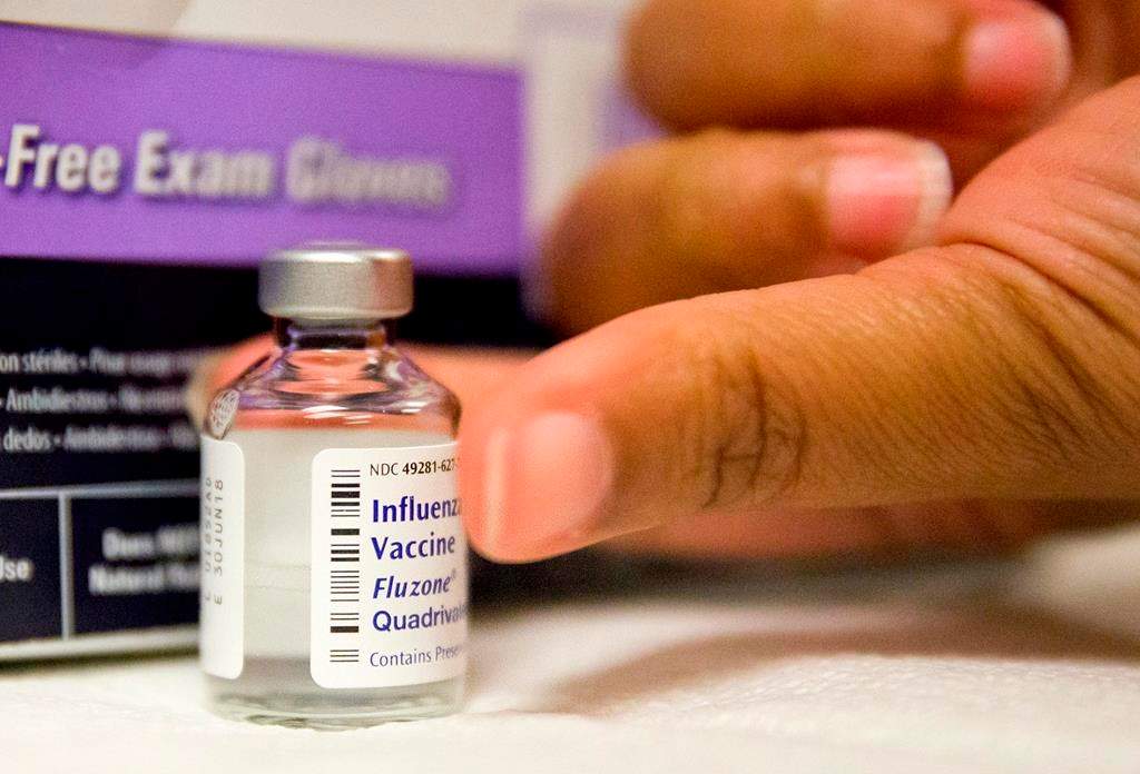 In this Wednesday, Feb. 7, 2018 file photo, a nurse prepares a flu shot from a vaccine vial at the Salvation Army in Atlanta.