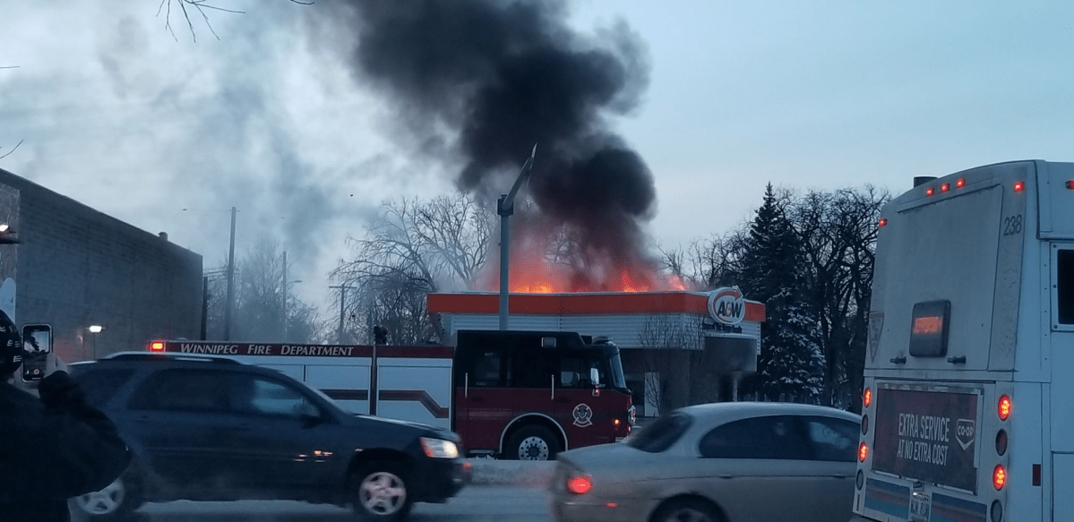 Flames shoot out of the roof of the A&W building Sunday night.