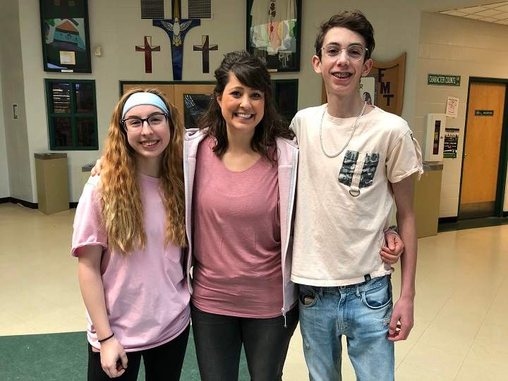 Father Michael Troy Junior High students Dean Larsen and Kaidence Dube pose with Lindsay Lipsett on Feb. 27, 2019.