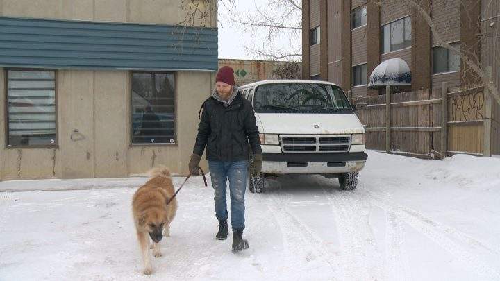 Jesse Boldt and his dog Layla walk by their converted Dodge cargo van.