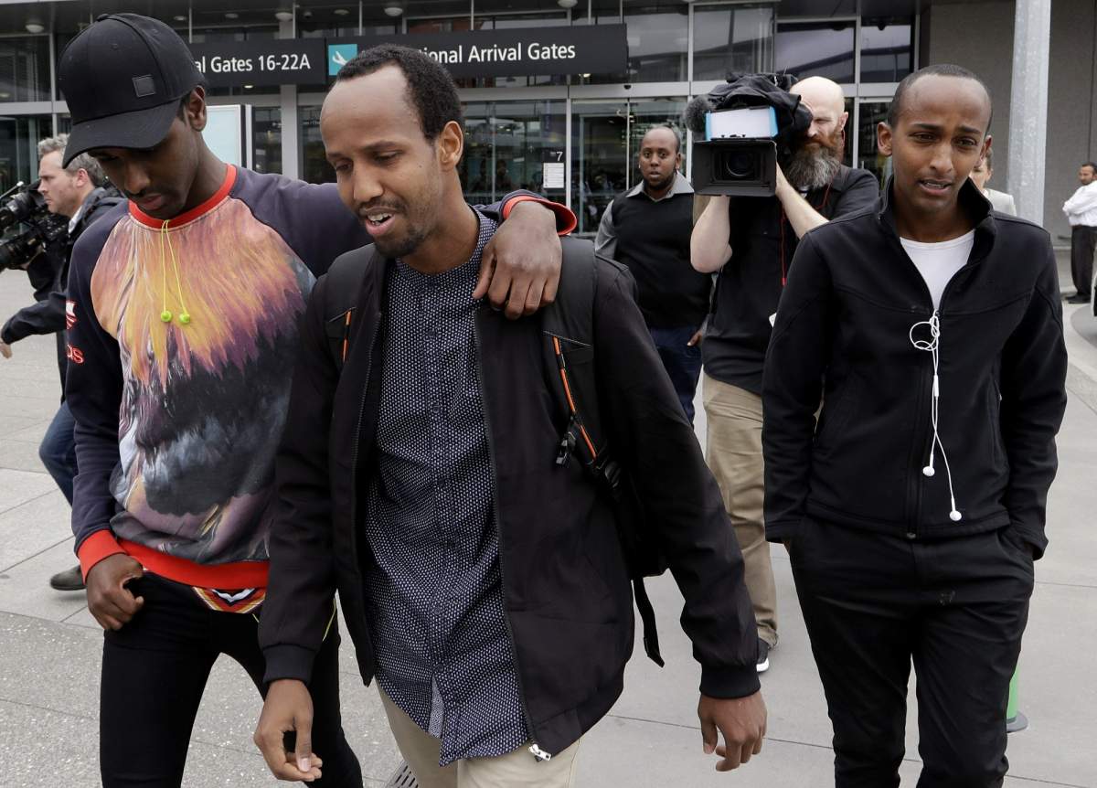 Abdifatah Ibrahim, center, and his brother Abdi, right, walk with an unidentified friend in Christchurch, New Zealand, Sunday, March 17, 2019.